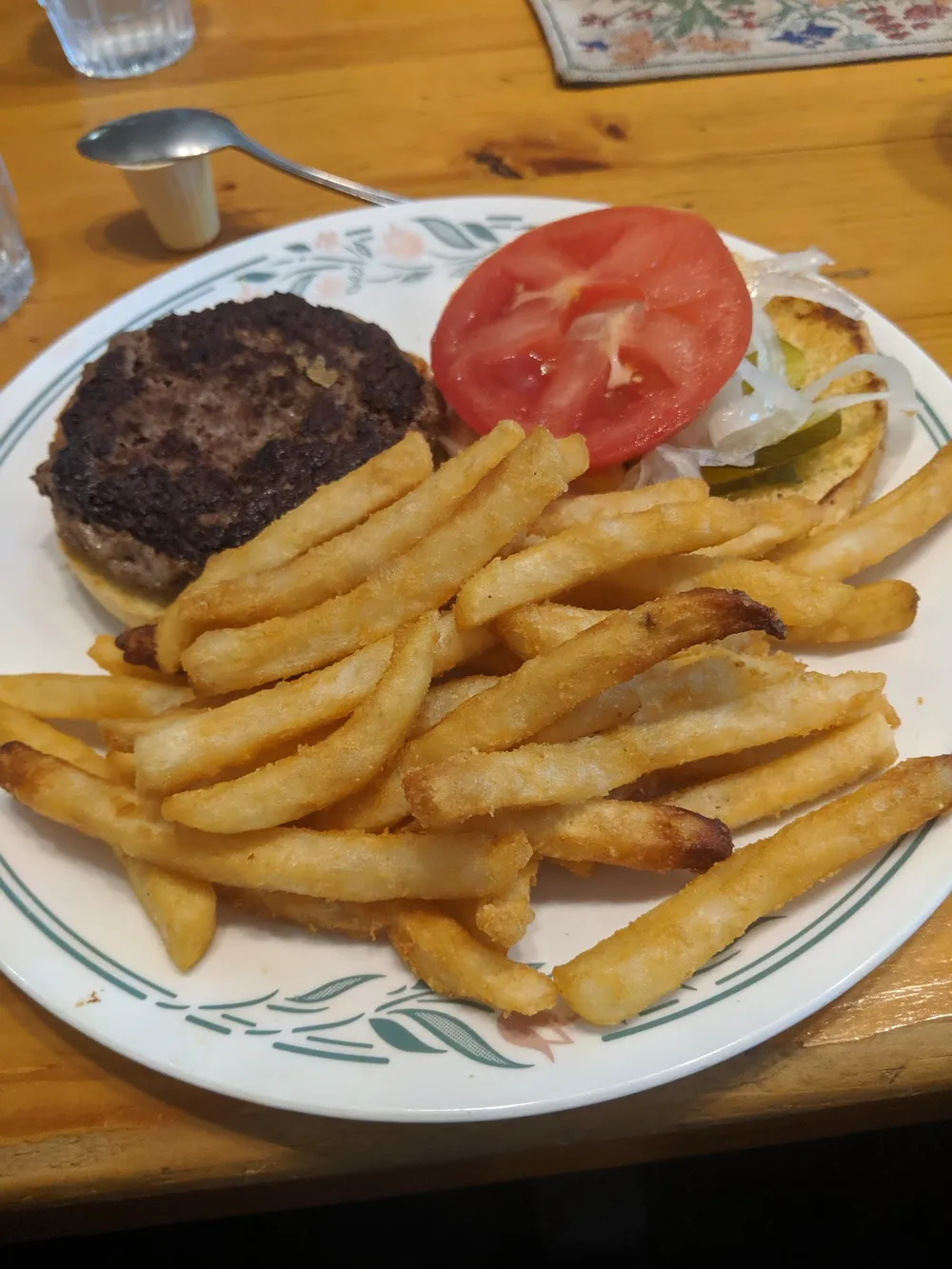 A homemade burger with tomato and a pile of fries