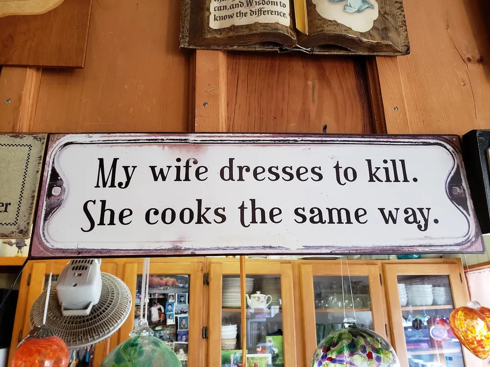 A sign: My wife dresses to kill. She cooks the same way.